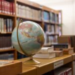 AIの勉強を始めるために本とノートパソコンを開いている様子