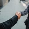 契約が成立して握手を交わす場面