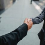 契約が成立して握手を交わす場面