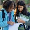 屋外で参考書を見ながら学ぶ学生