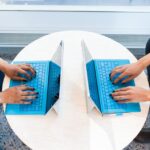 1台のキーボードに2人が手を伸ばしている様子