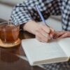机で英語のノートに書き込みながら学習する様子