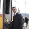 駅のホームで電車に乗り込むビジネスパーソン