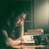 暗い部屋で机に向かい本を読む人