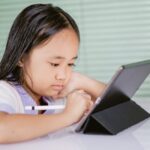 タブレットを見ながら学習する子ども