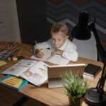 机に向かって学習する子どもと文房具