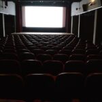 座席が並ぶ誰もいない映画館のスクリーン