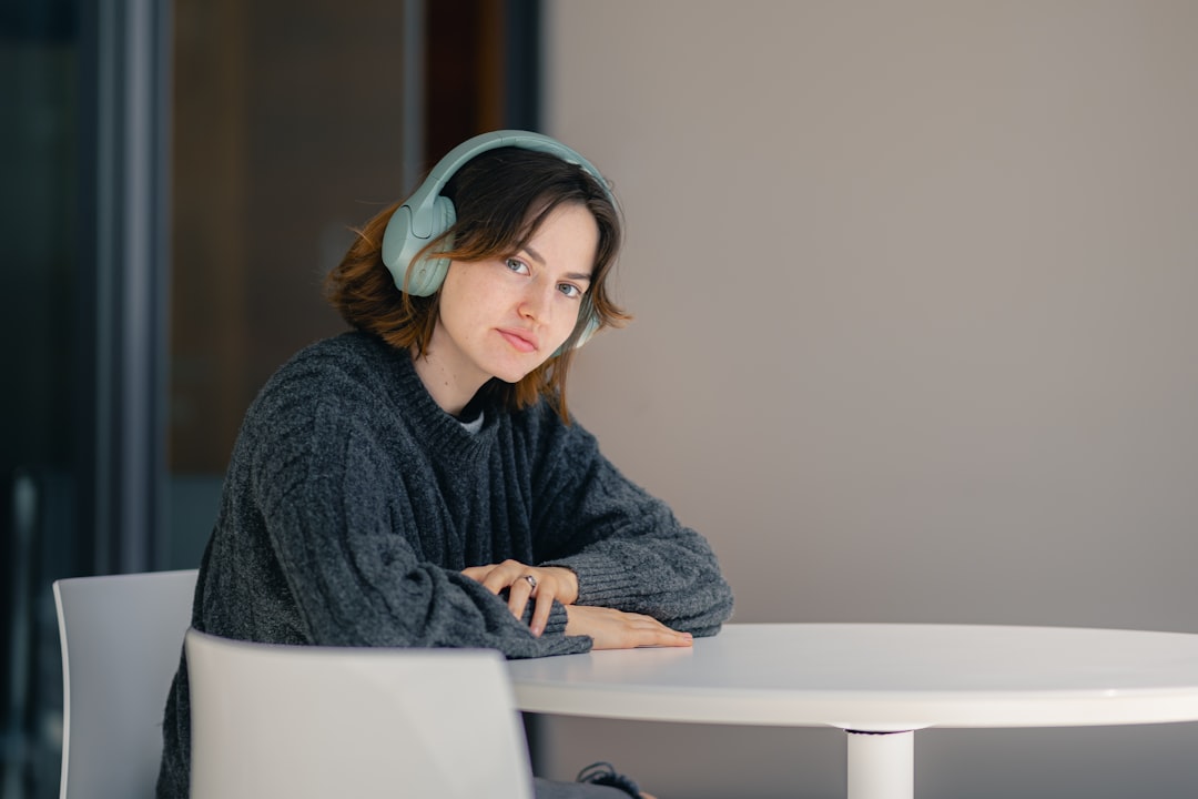 ヘッドホンをつけてテーブルに座る女性