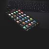 ノートパソコンのキーボードの上に置かれたアプリアイコンが並ぶスマートフォン