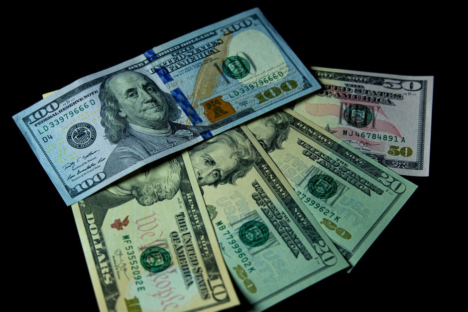机の上に重なった米ドル紙幣の束