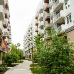 緑の並木道沿いに建つ中層マンションの外観