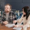 キッチンテーブルで書類を見ながら話し合う男女