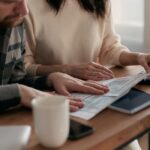 夫婦で家計の書類を確認しながら計算機で計算している様子