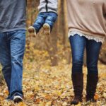 紅葉の中を歩く親子の後ろ姿
