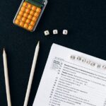 黒い背景に置かれたサイコロと申告書類、ペンシル