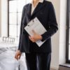 クリップボードを持ちスーツを着た女性が空室の部屋に立っている