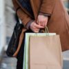 紙袋のショッピングバッグを複数持って歩く人