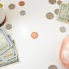 白い机に並べたドル紙幣と硬貨、観葉植物