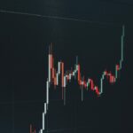 暗い画面に表示された赤と緑のローソク足チャート