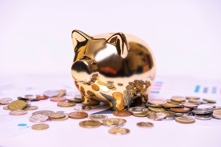 金色のぶた型貯金箱と散らばった硬貨