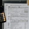 iDeCoの節税効果をイメージさせる電卓と書類のイメージ