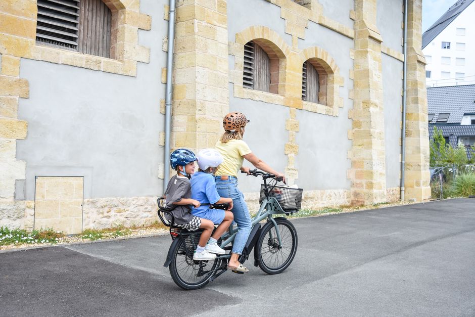子どもを後ろに乗せて自転車をこぐ親子