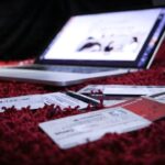 NISA口座の書類確認をイメージさせるパソコンと書類のイメージ