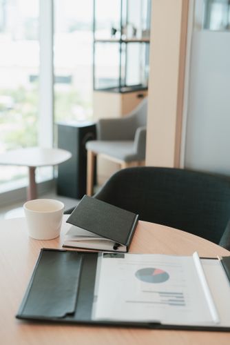 円グラフの資料とコーヒーが置かれたテーブル