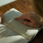 英語の本の文章を指でたどりながら読む手元