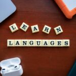 LEARN LANGUAGESの文字タイルとノートパソコン、イヤホン