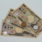 テーブルに広げた一万円札・五千円札と硬貨