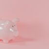 ピンクの背景に置かれた白い貯金箱