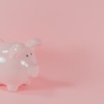 ピンクの背景に置かれた白い貯金箱