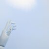 青空を背景にした白いロボットハンド