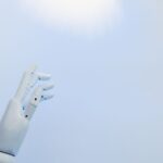 青空を背景にした白いロボットハンド