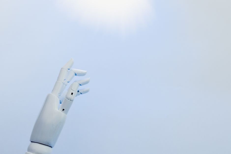 青空を背景にした白いロボットハンド