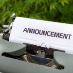「ANNOUNCEMENT」と書かれた紙が挟まれたレトロなタイプライター