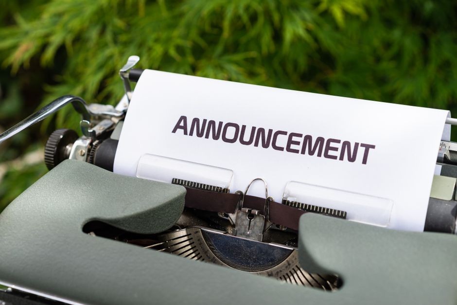 「ANNOUNCEMENT」と書かれた紙が挟まれたレトロなタイプライター
