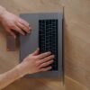 デスクの上でノートパソコンを操作しながら書類を確認する手元