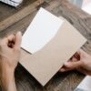 デスクの上で郵便物と書類を開封して中身を確認する様子