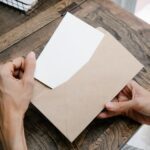 デスクの上で郵便物と書類を開封して中身を確認する様子