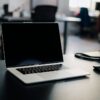 在宅のデスクでノートパソコンの証券会社サイトを操作する手元