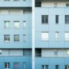 マンションの外観写真と部屋の図面を見比べている手元