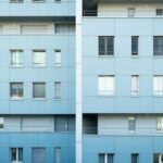 マンションの外観写真と部屋の図面を見比べている手元