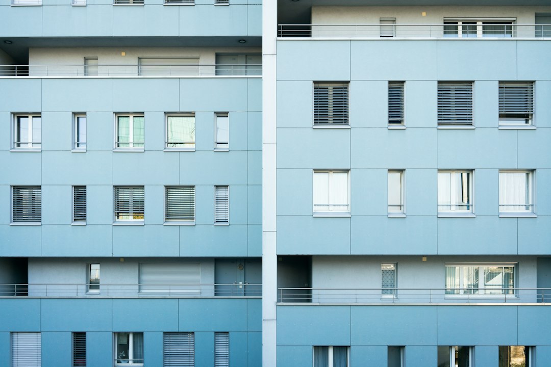 マンションの外観写真と部屋の図面を見比べている手元