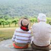 海辺の丘で寄り添って景色を眺めるシニア夫婦の後ろ姿