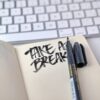 ノートに『TAKE A BREAK』と手書きされたメモとペン