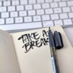 ノートに『TAKE A BREAK』と手書きされたメモとペン