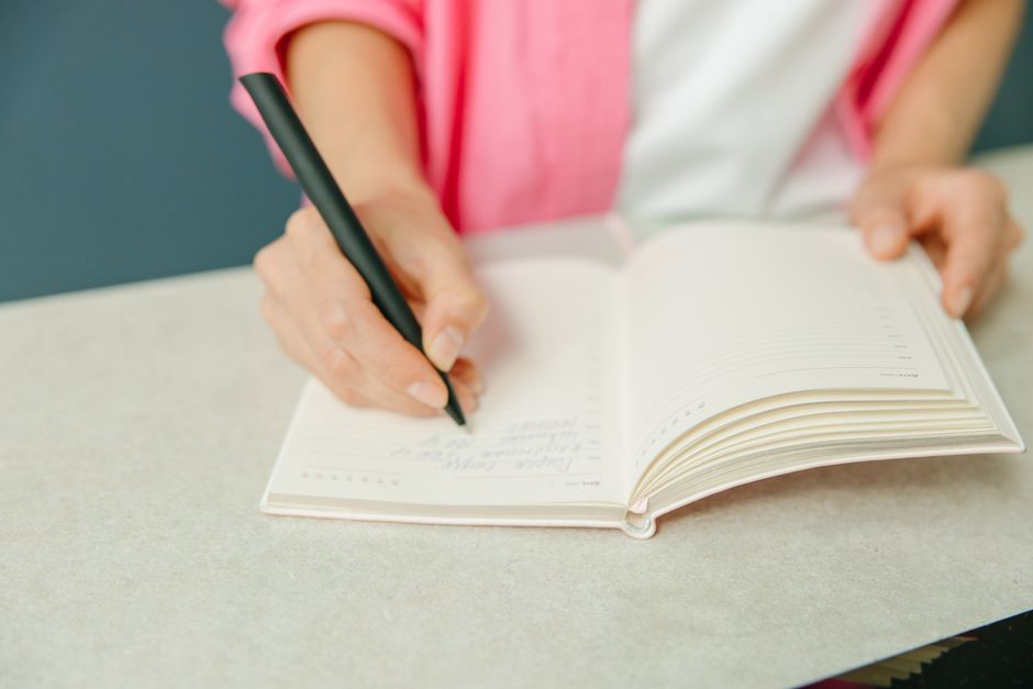 手帳に予定を書き込む手元
