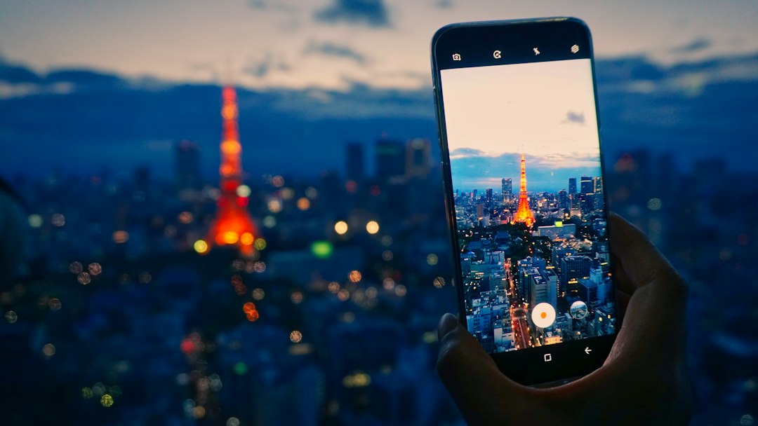 スマートフォンで東京タワーの夜景を撮影する手元